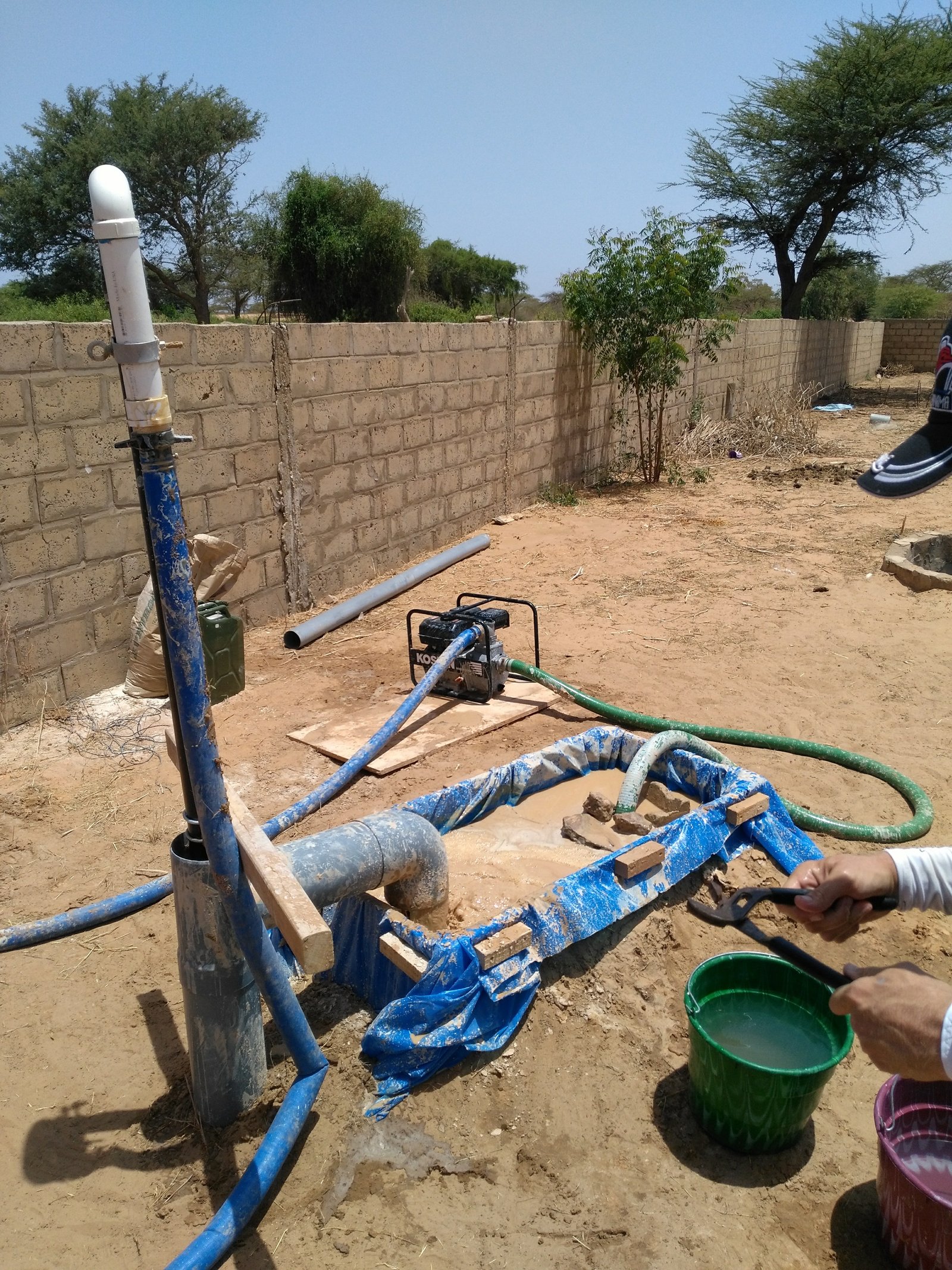 Samuel D. Hodges with village members operating slurry-powered drilling equipment in Senegal